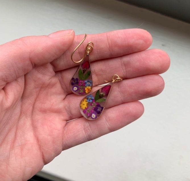 A reviewer holding the earrings 