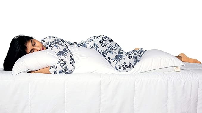 Person hugging a body pillow and sleeping.
