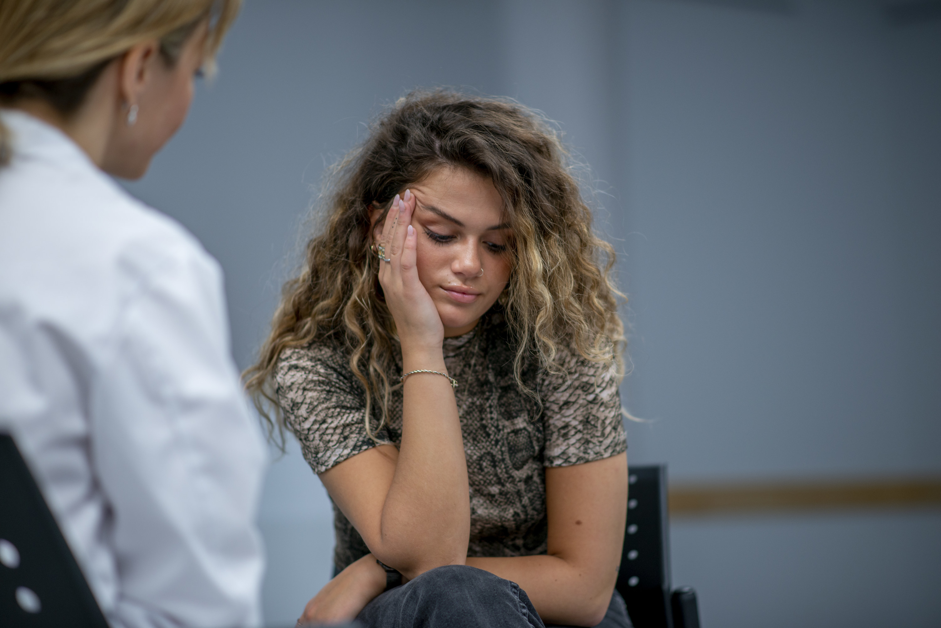 A young girl who appears under distress while speaking to a doctor 