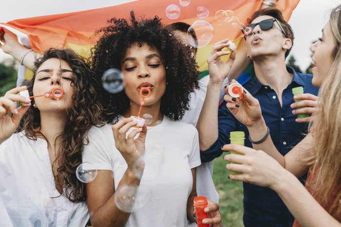 Friends blowing bubbles together at a park