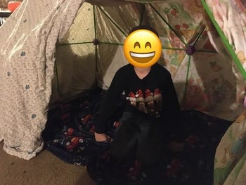 a reviewer sitting inside the fort they built