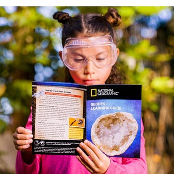 a model holding the national geographic geode book