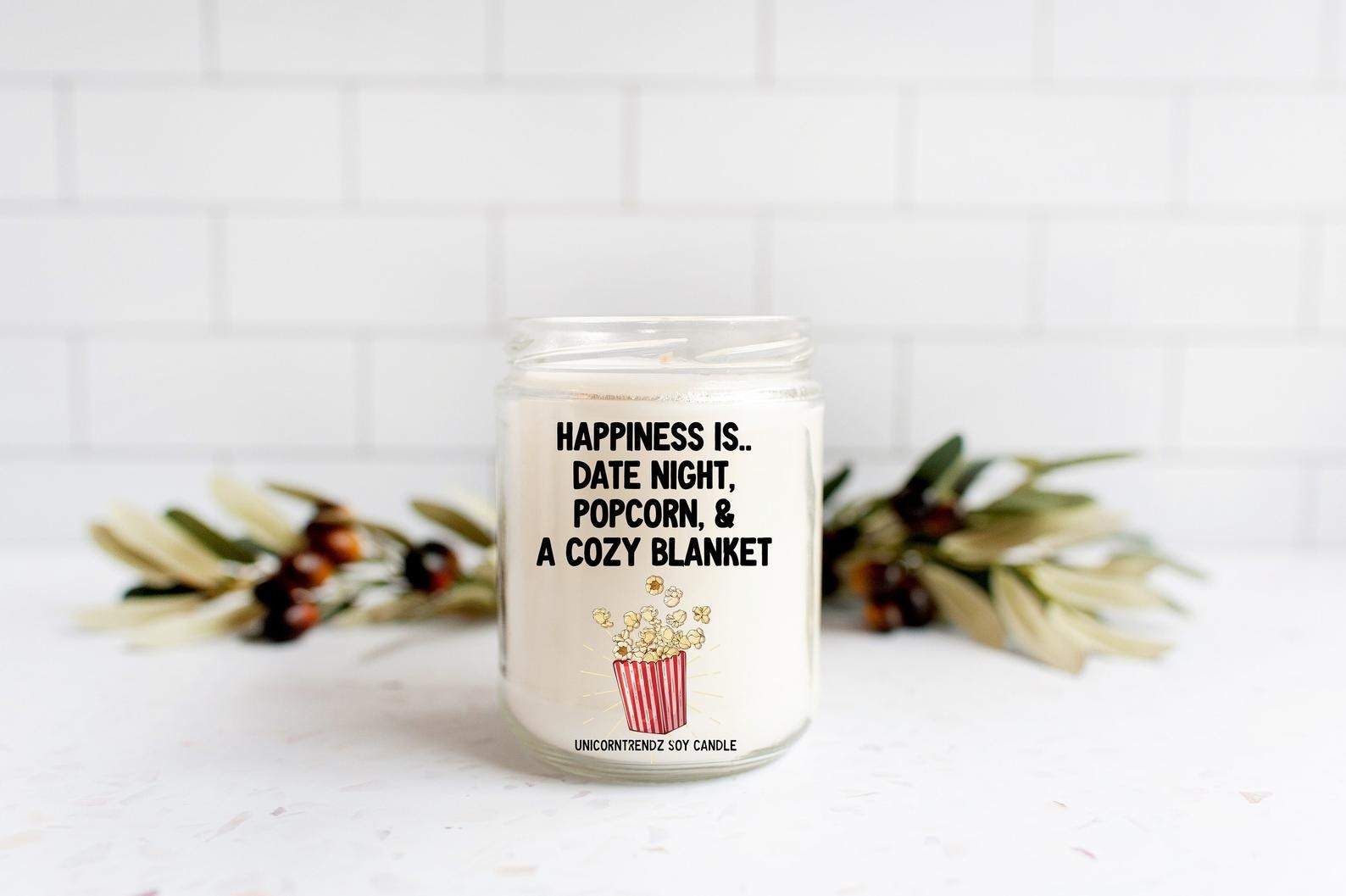the candle that says happiness is date night, popcorn, and a cozy blanket