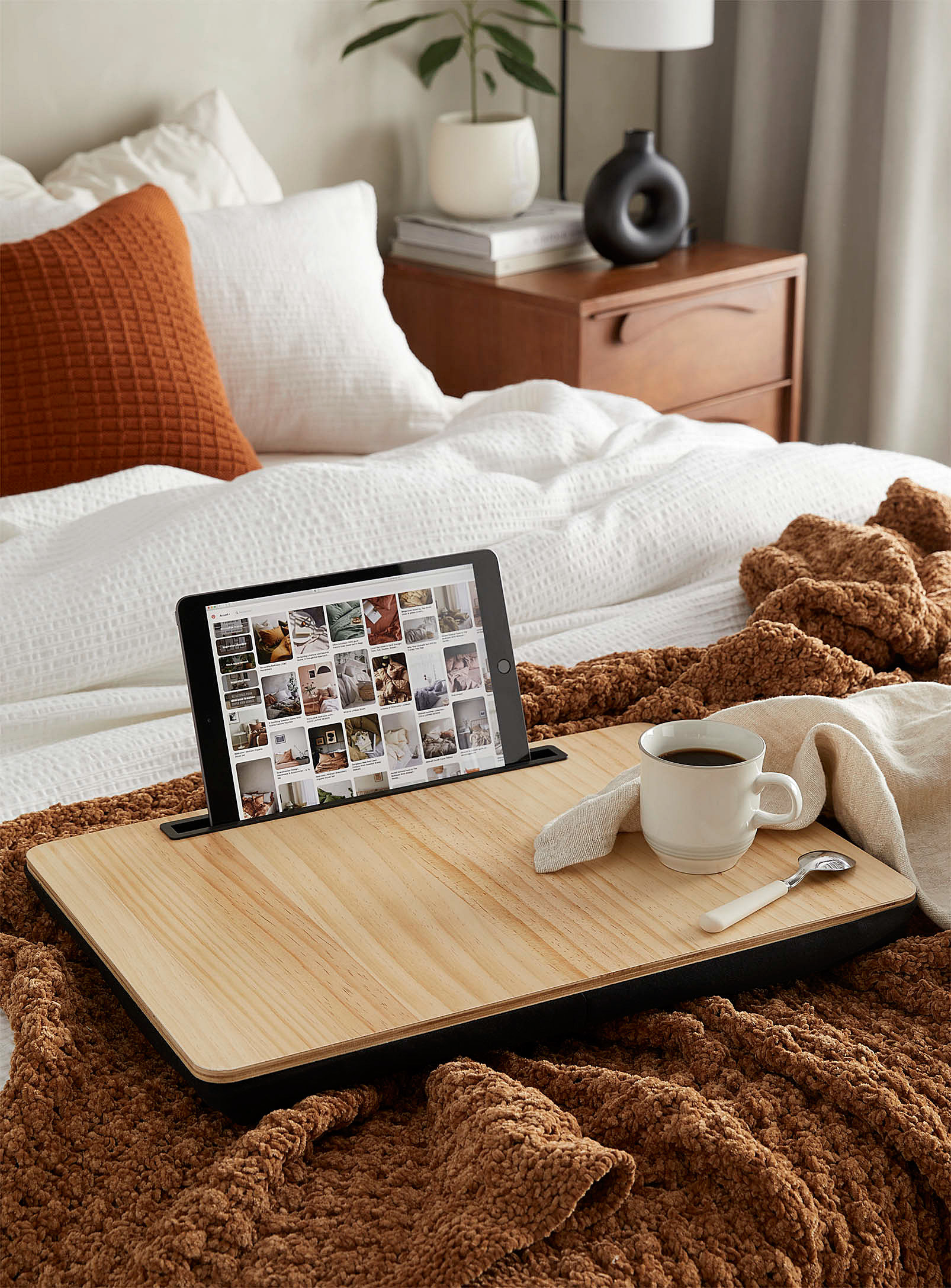 the lap desk on a bed with a coffee and a tablet