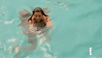 Kim holds her ears while treading water in the ocean