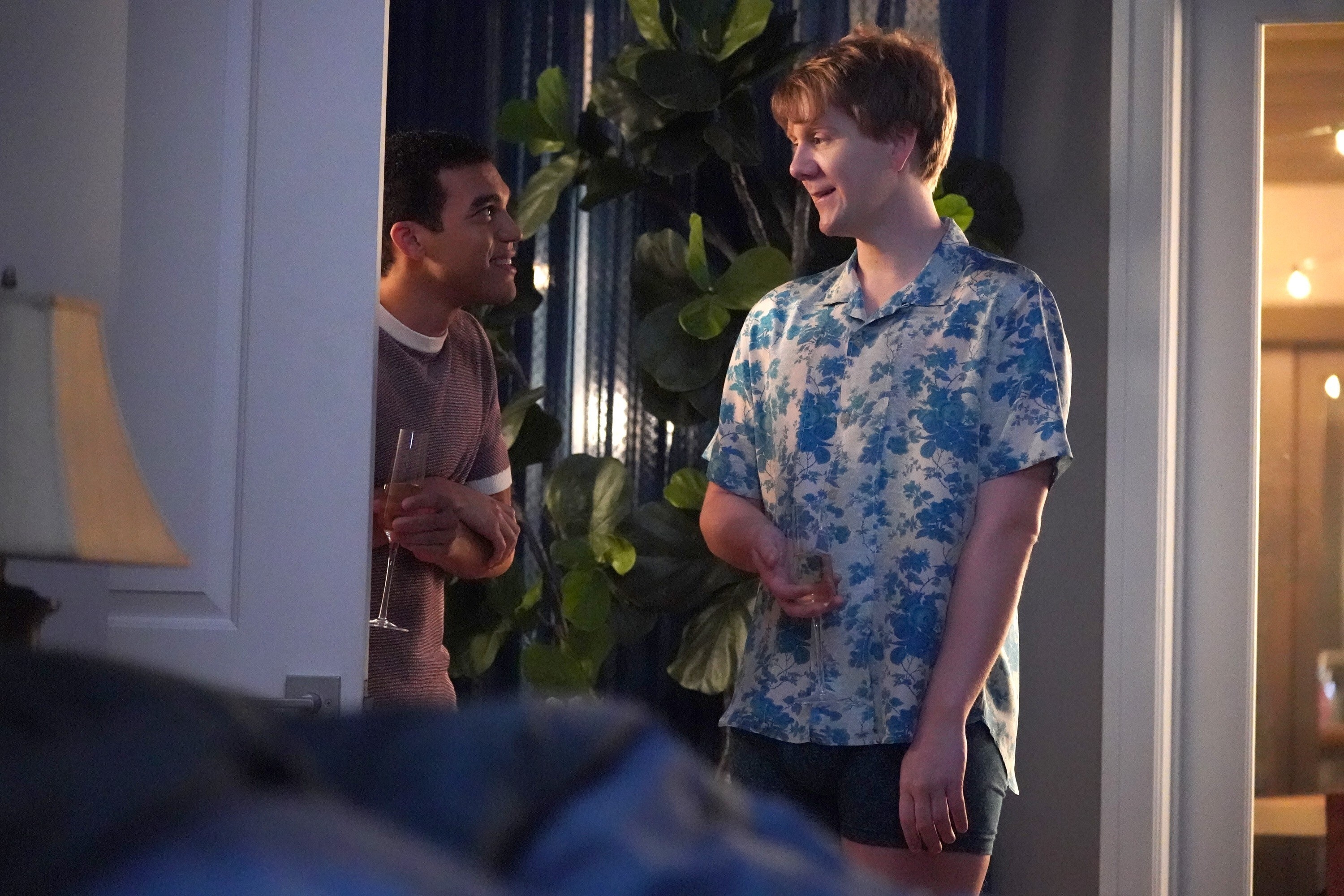 Adam Faison and Josh Thomas talk in a doorway