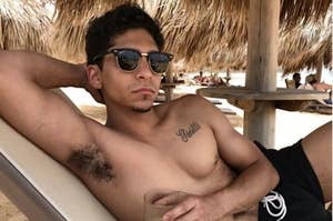 Angel Bismark Curiel lying shirtless on the beach 