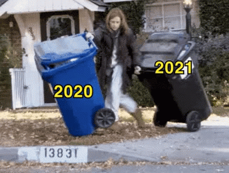 A woman pushes a 2020 trash can that falls over and barely holds onto a 2021 one