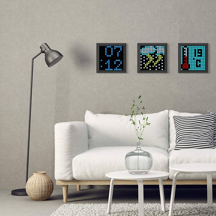 3 pixel art frames hanging on a wall showing art, temprature, and time.