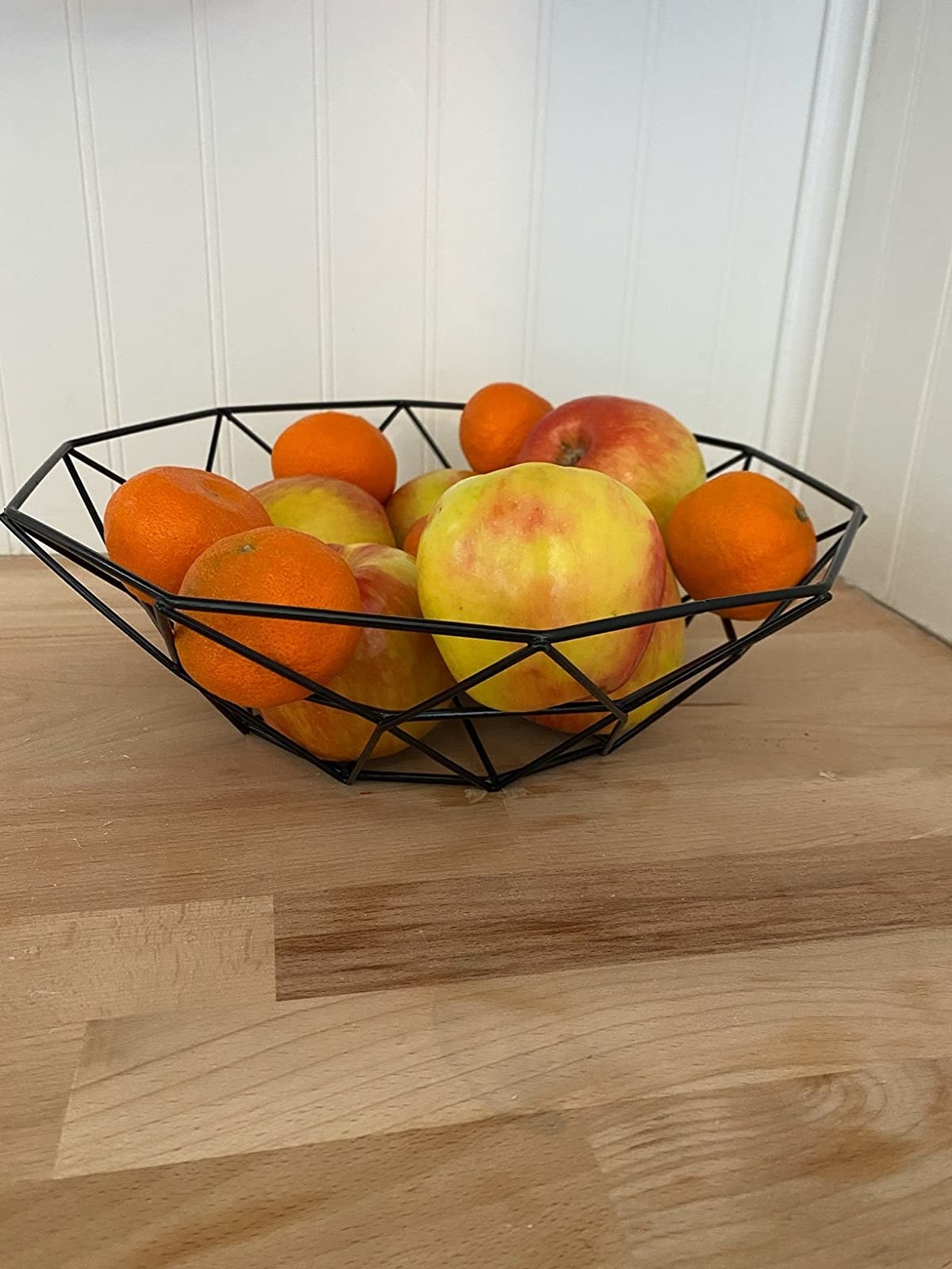 A reviewer photo of the wire bowl filled with fruit
