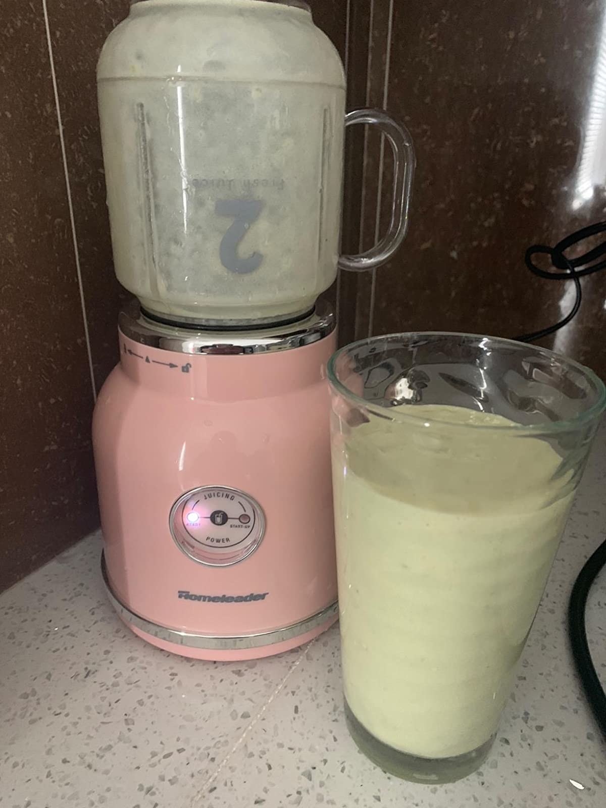 A reviewer photo of the blender and a smoothie blended in the blender