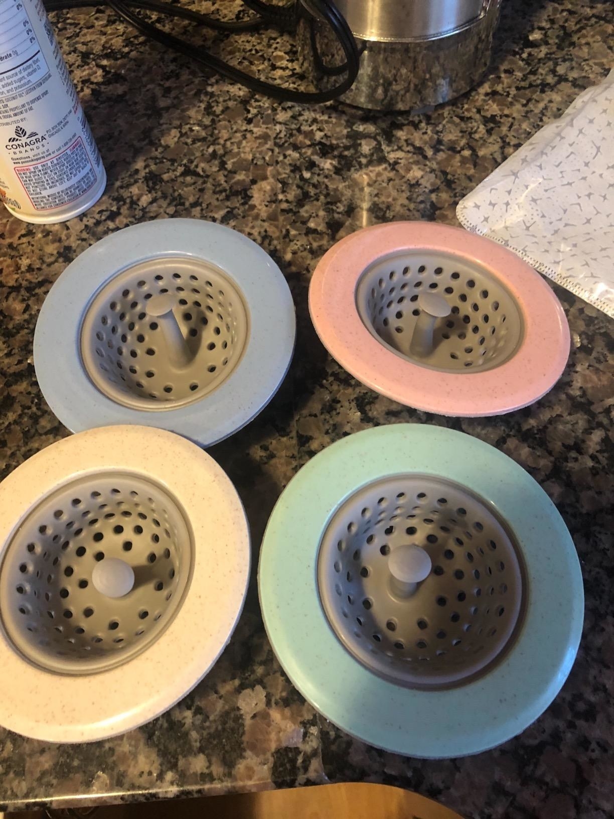 A reviewer photo of the strainers, which have gray centers and pastel-colored rims