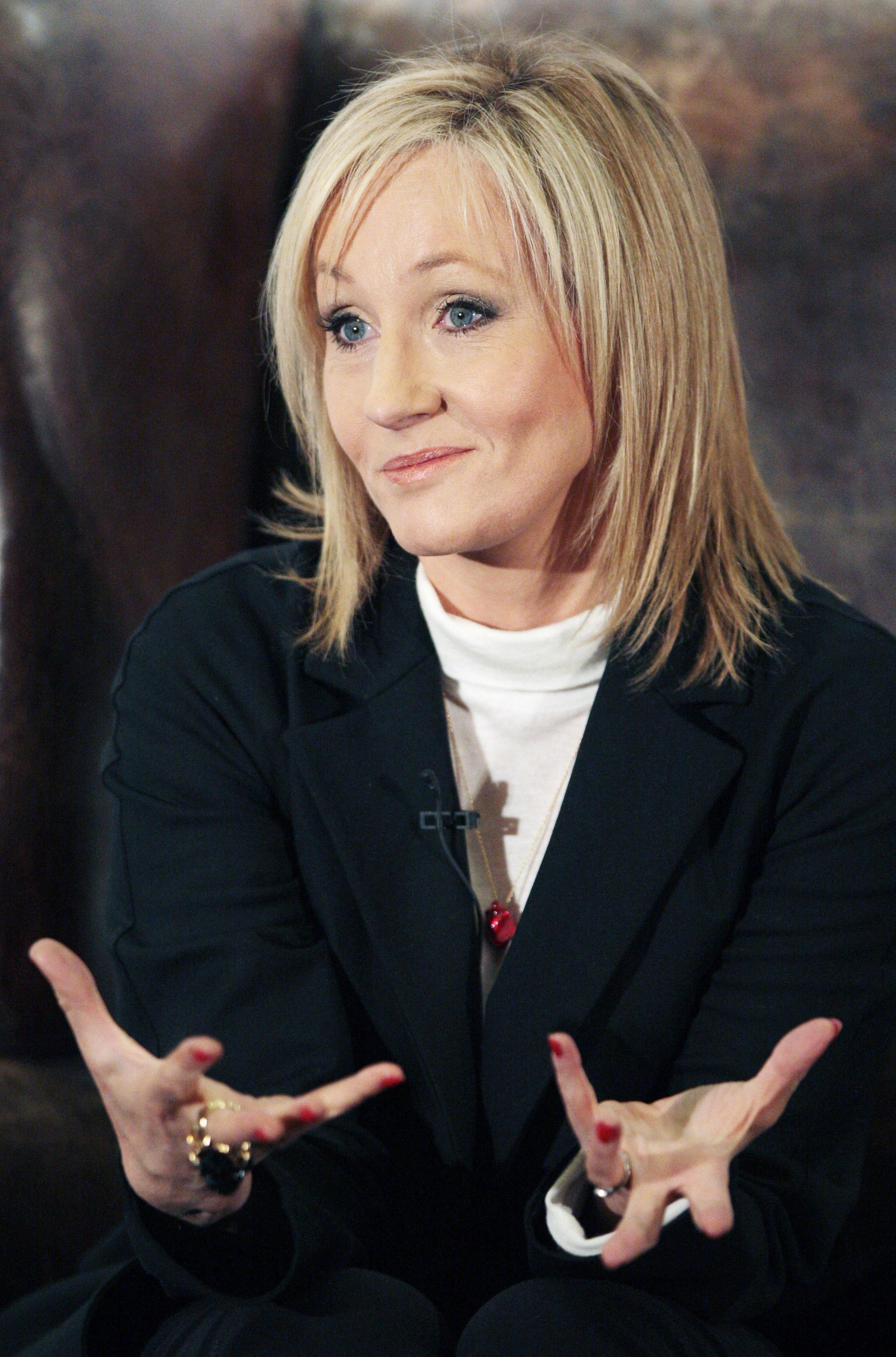 J.K. Rowling with her hands raised with palms up