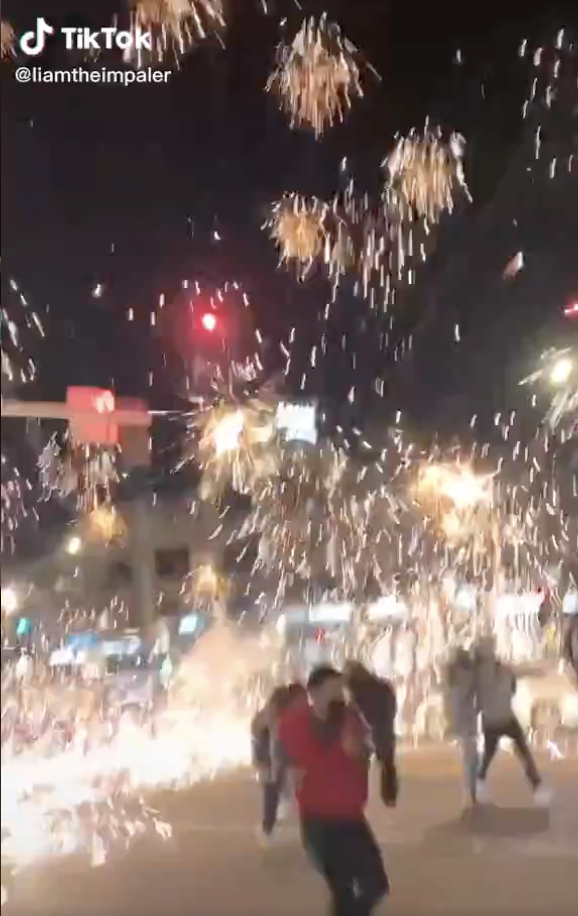 Fireworks going off as people run