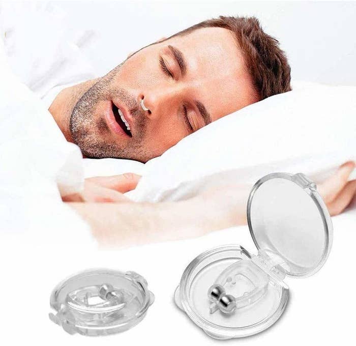 A person sleeping with the anti-snore clip in their nose.