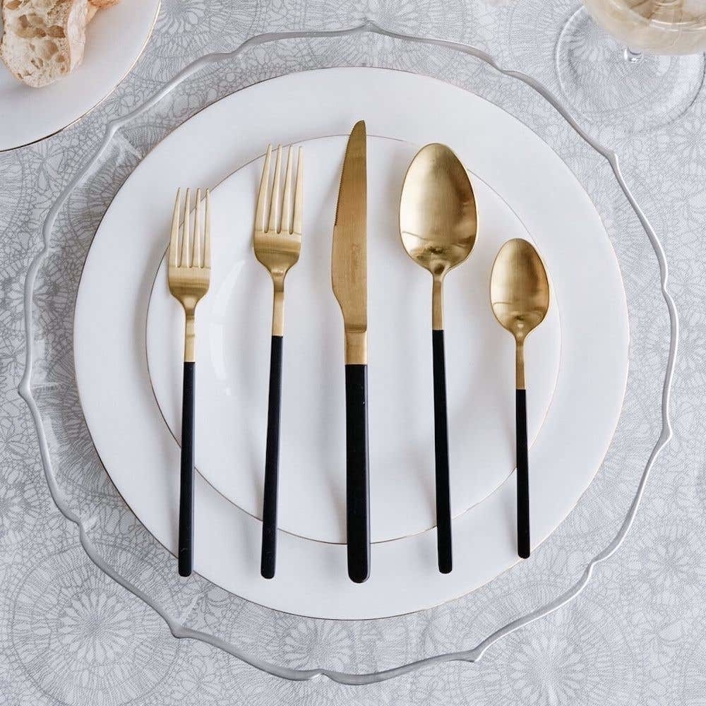 A plate with two forks, a knife, and two spoons on it