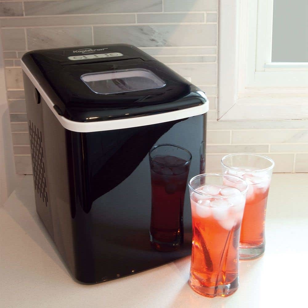A large square machine with two glasses full of juice and ice