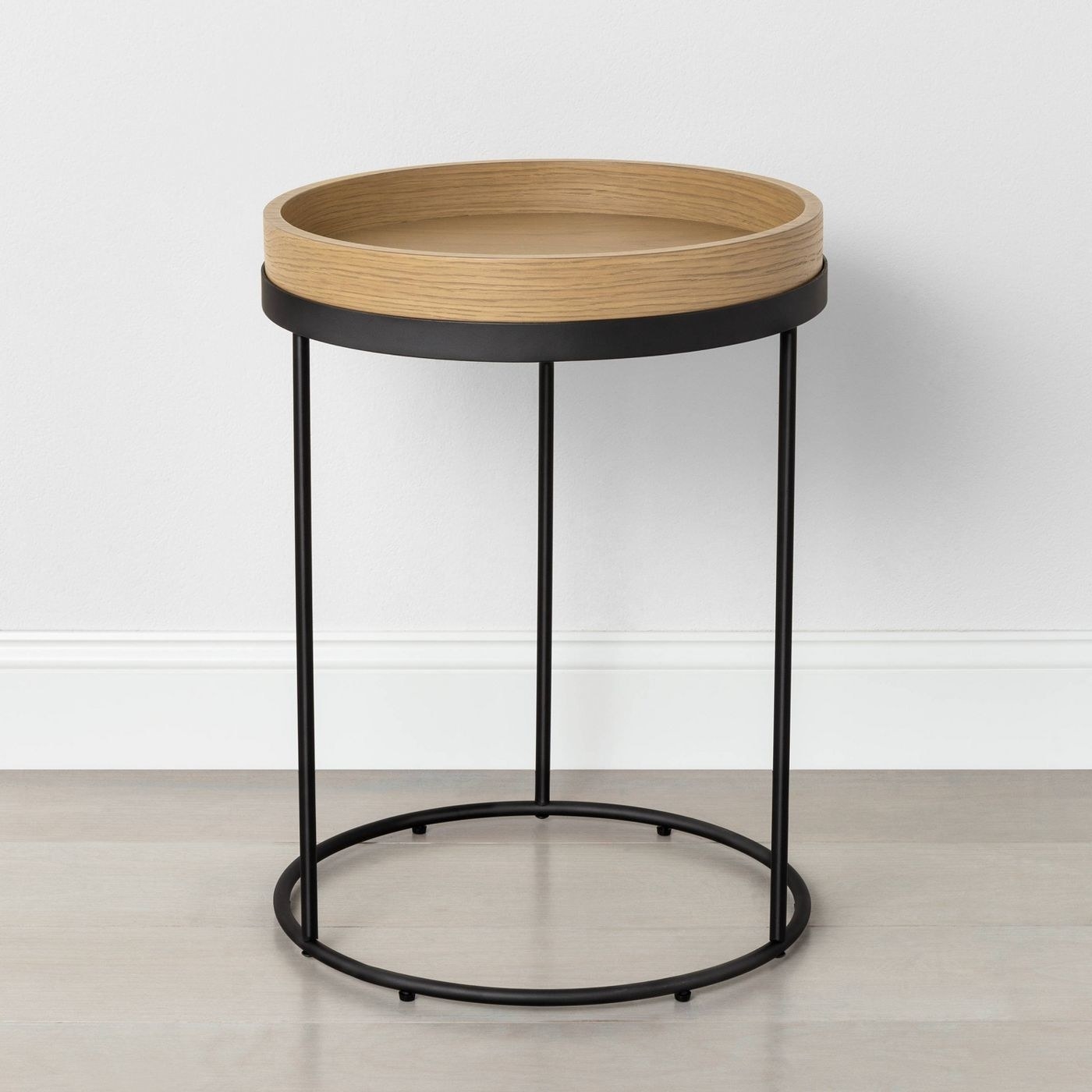End table with light wood circular top and black metal frame