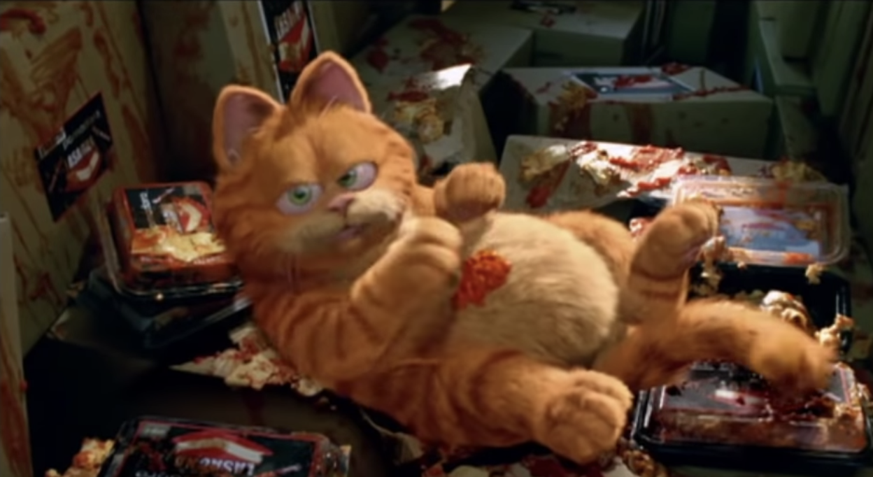 Garfield laying down eating sauce off his belly