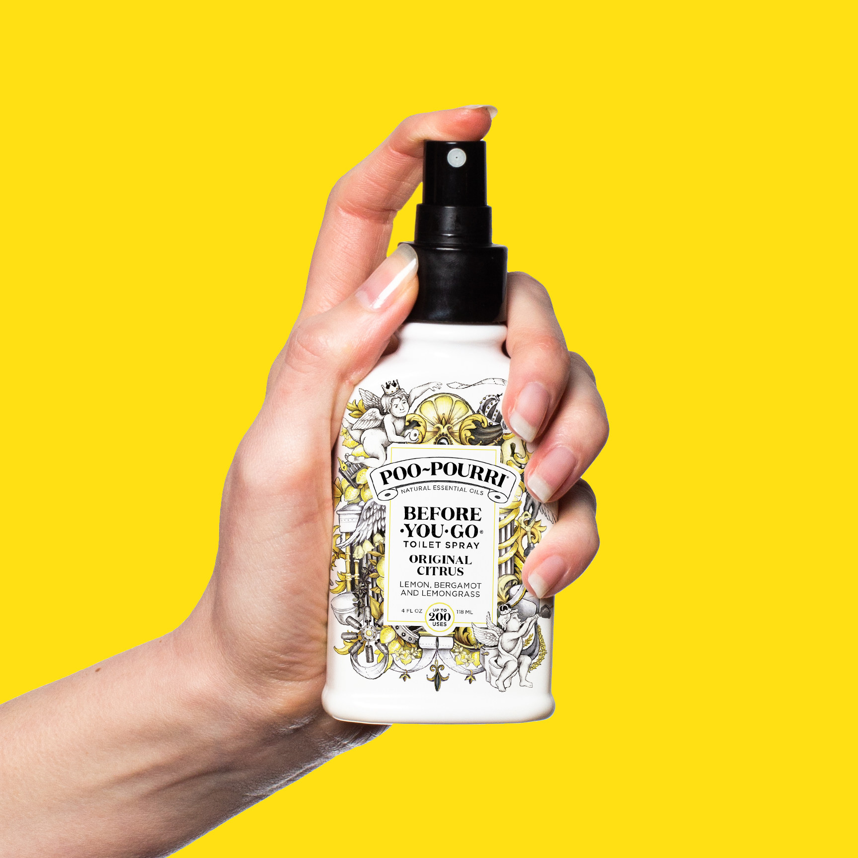 a model&#x27;s hand hold the poo-pourri spray bottle in front of a bright yellow background