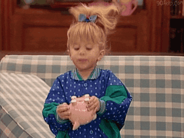 Michelle from &quot;Full House&quot; shaking a piggy bank.