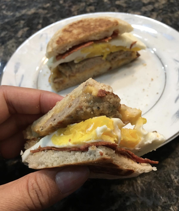 reviewer holding egg sandwich 