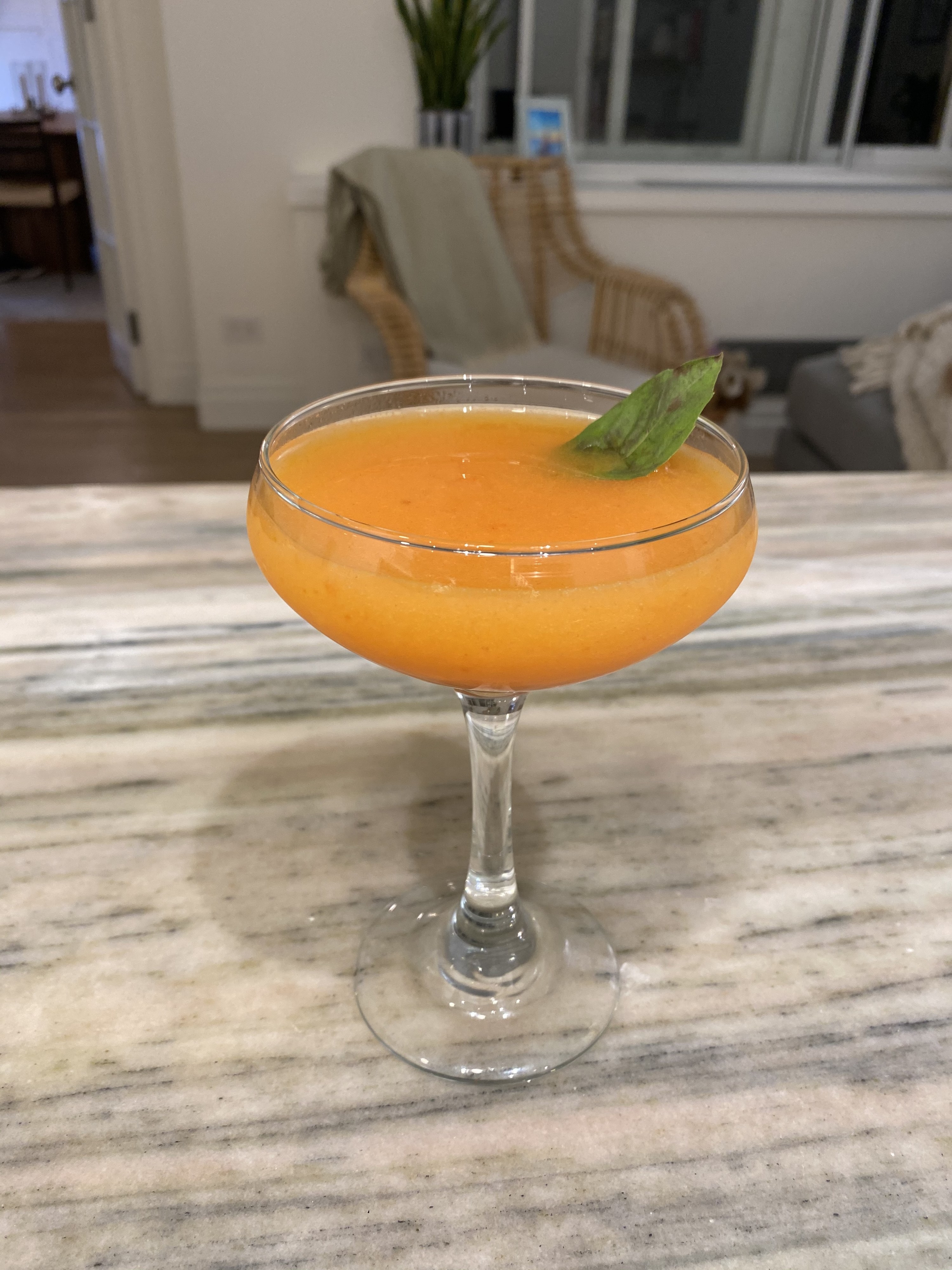 An orange sour blossom cocktail in a coupe.