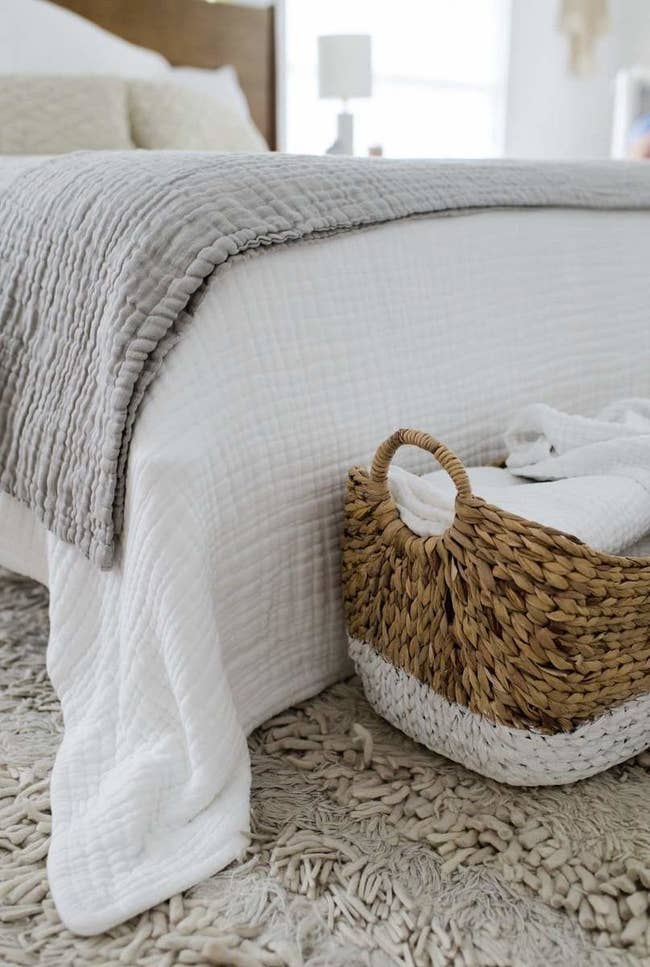a grey throw and white throw on a bed