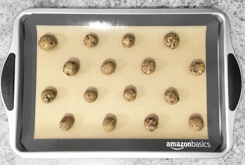 A reviewer&#x27;s silicone baking mat on a baking sheet with cookie dough spread out