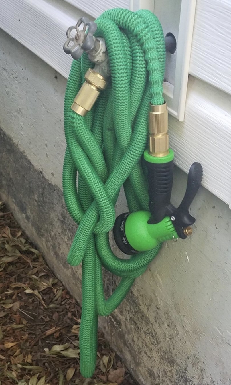 the hose wrapped around an outdoor water tap