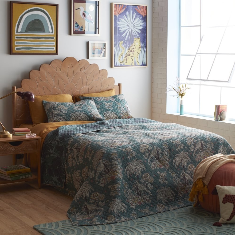 The quilt set featuring a vintage bird and plant pattern, on a bed