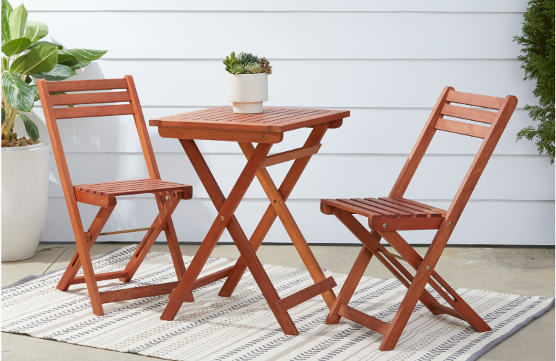 a pair of wooden folding chairs next to a wooden folding table 