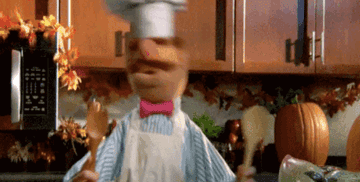 A muppet dancing with kitchen utensils