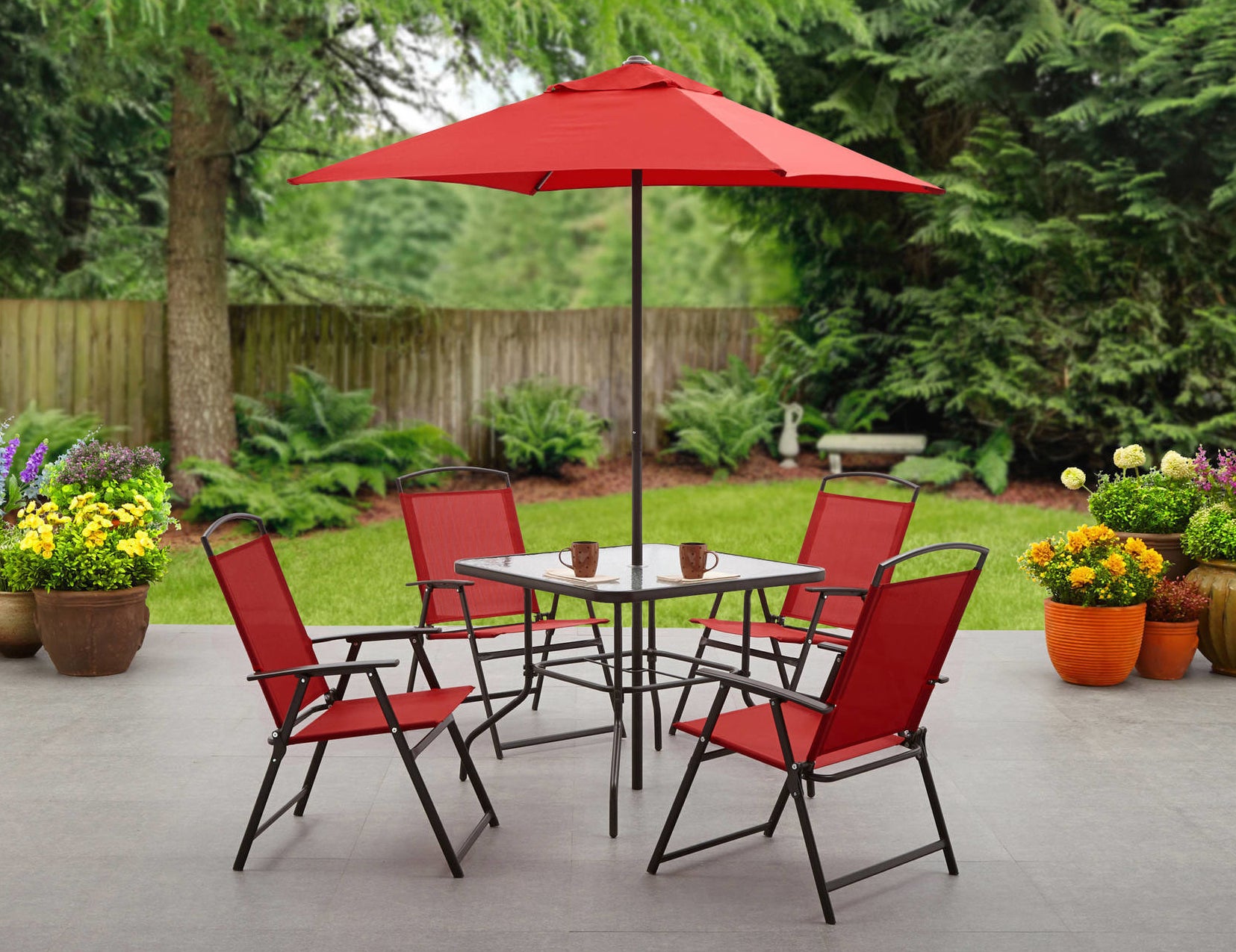 four matching red folding chairs, a square table, and a center folding umbrella 