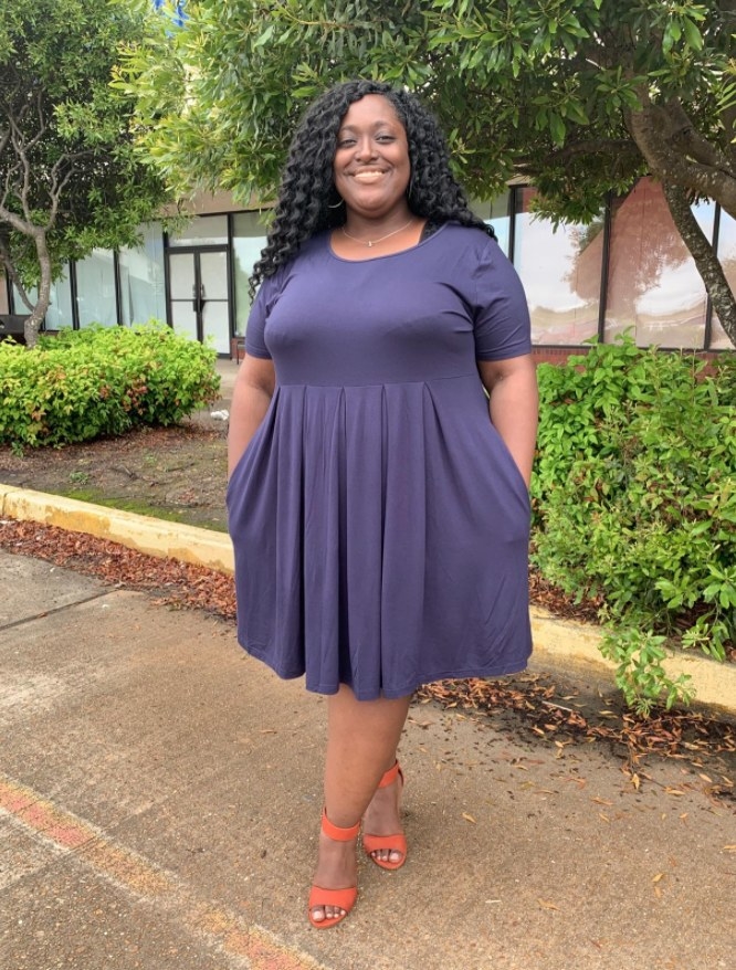 A reviewer wearing the dress in navy blue 