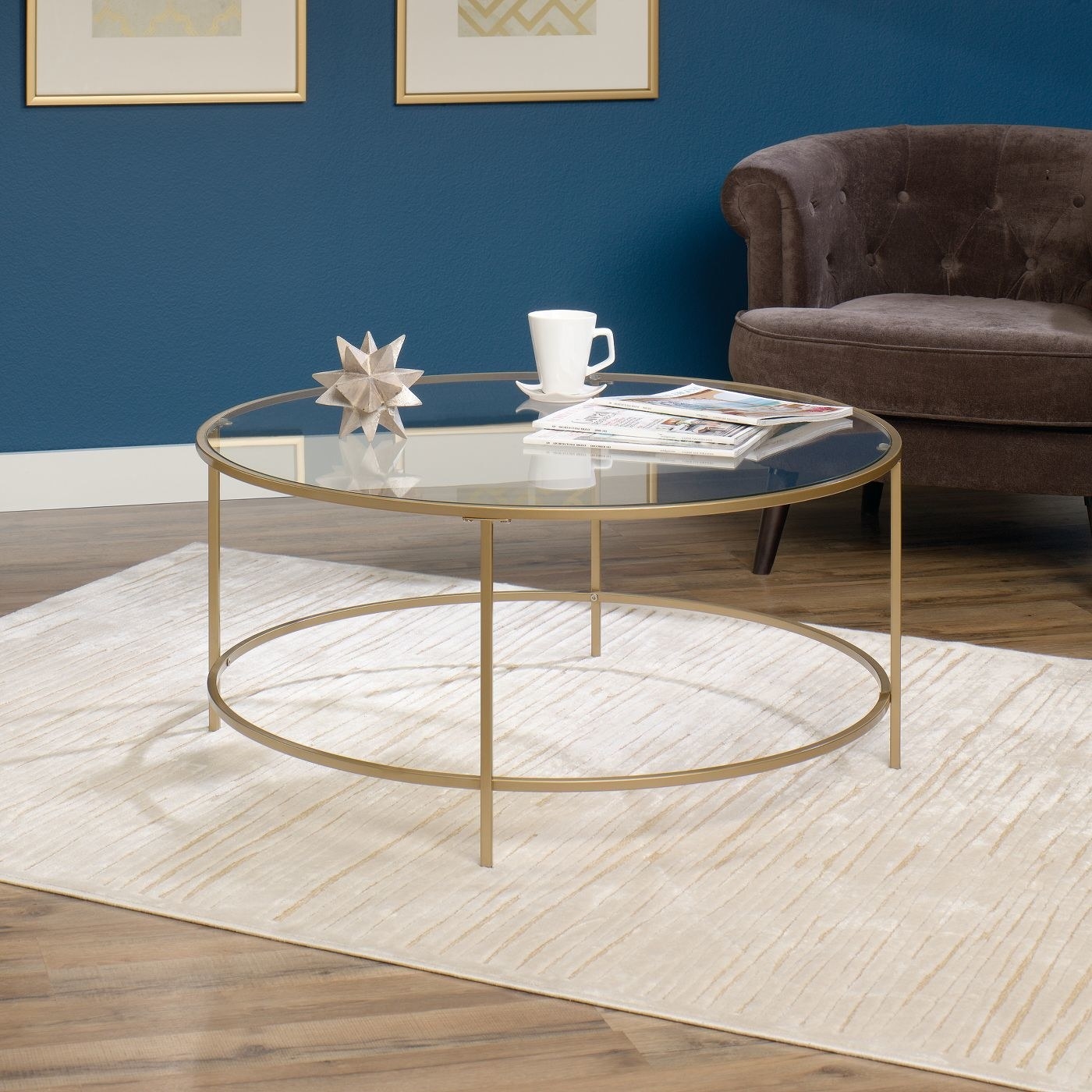 Circular table with gold metal frame and glass top