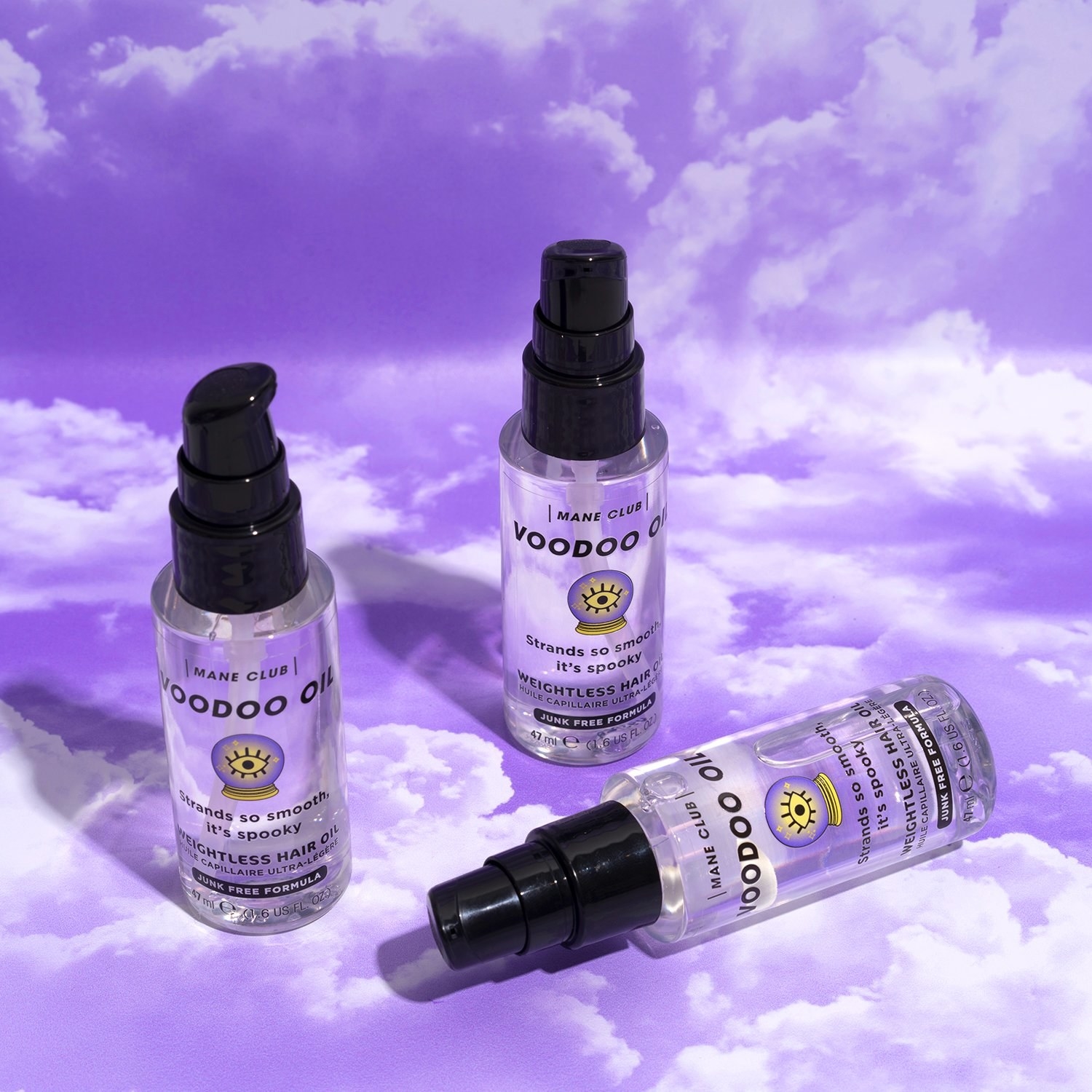 bottles of hair oil styled on purple cloud background