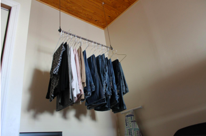 a reviewer photo of clothes hanging on the rod from a ceiling 