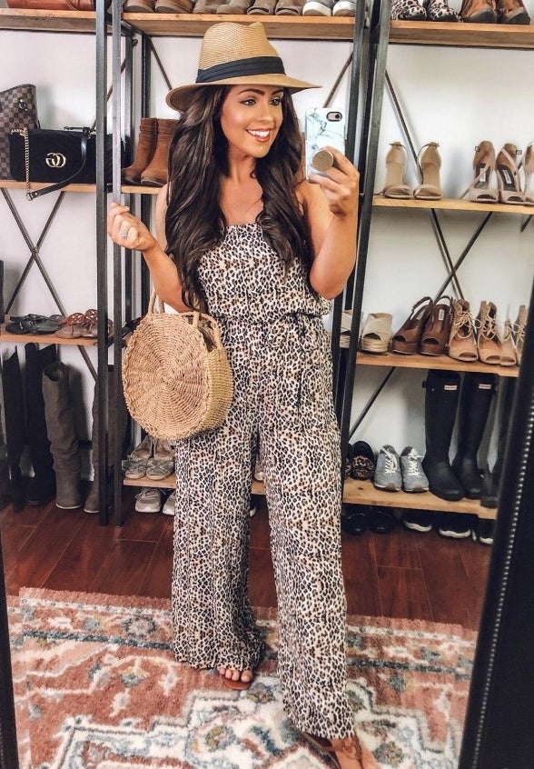 A reviewer wearing the leopard print women&#x27;s strapless, wide-legged jumpsuit