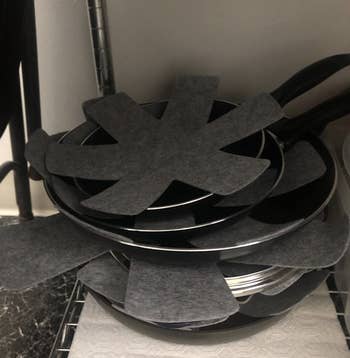 Reviewer image of pans stacked with star shaped gray potholders 