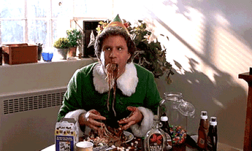 Buddy the Elf eating spaghetti drenched in chocolate sauce.