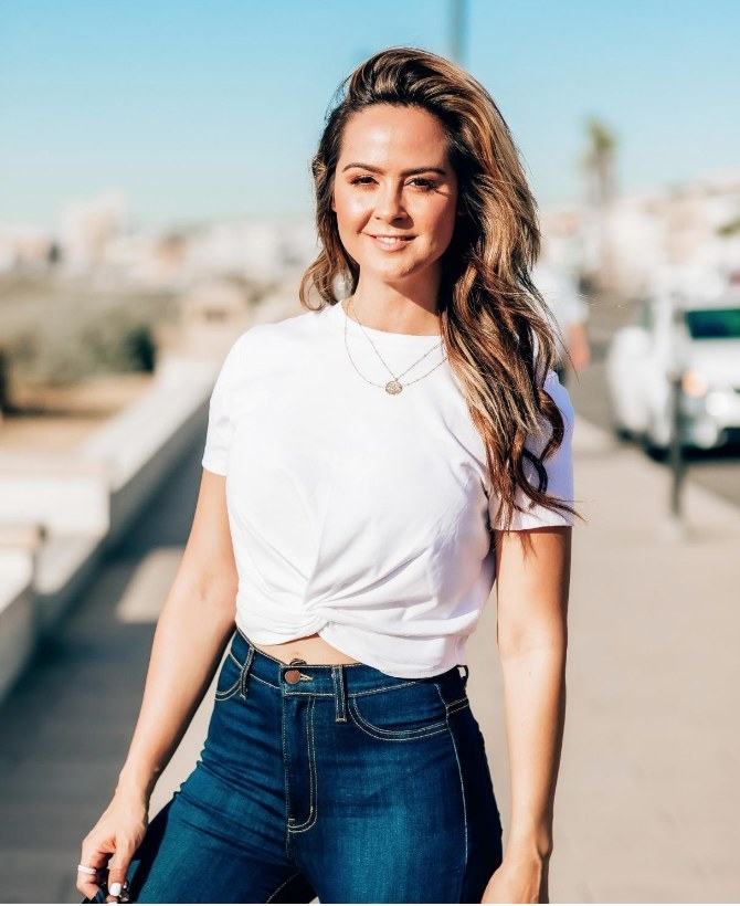 A reviewer wearing a white crop t-shirt with a twist front 