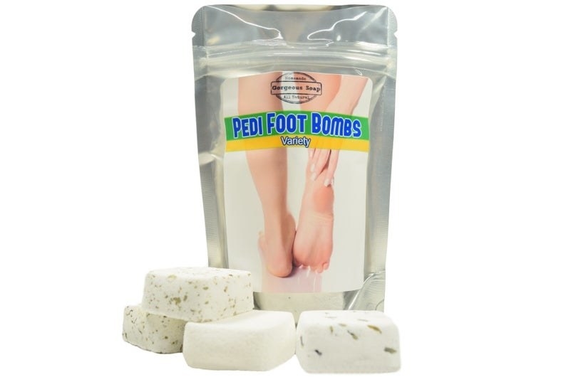 a silver bag that says &quot;pedi foot bombs&quot; next to a pile of small square bombs 