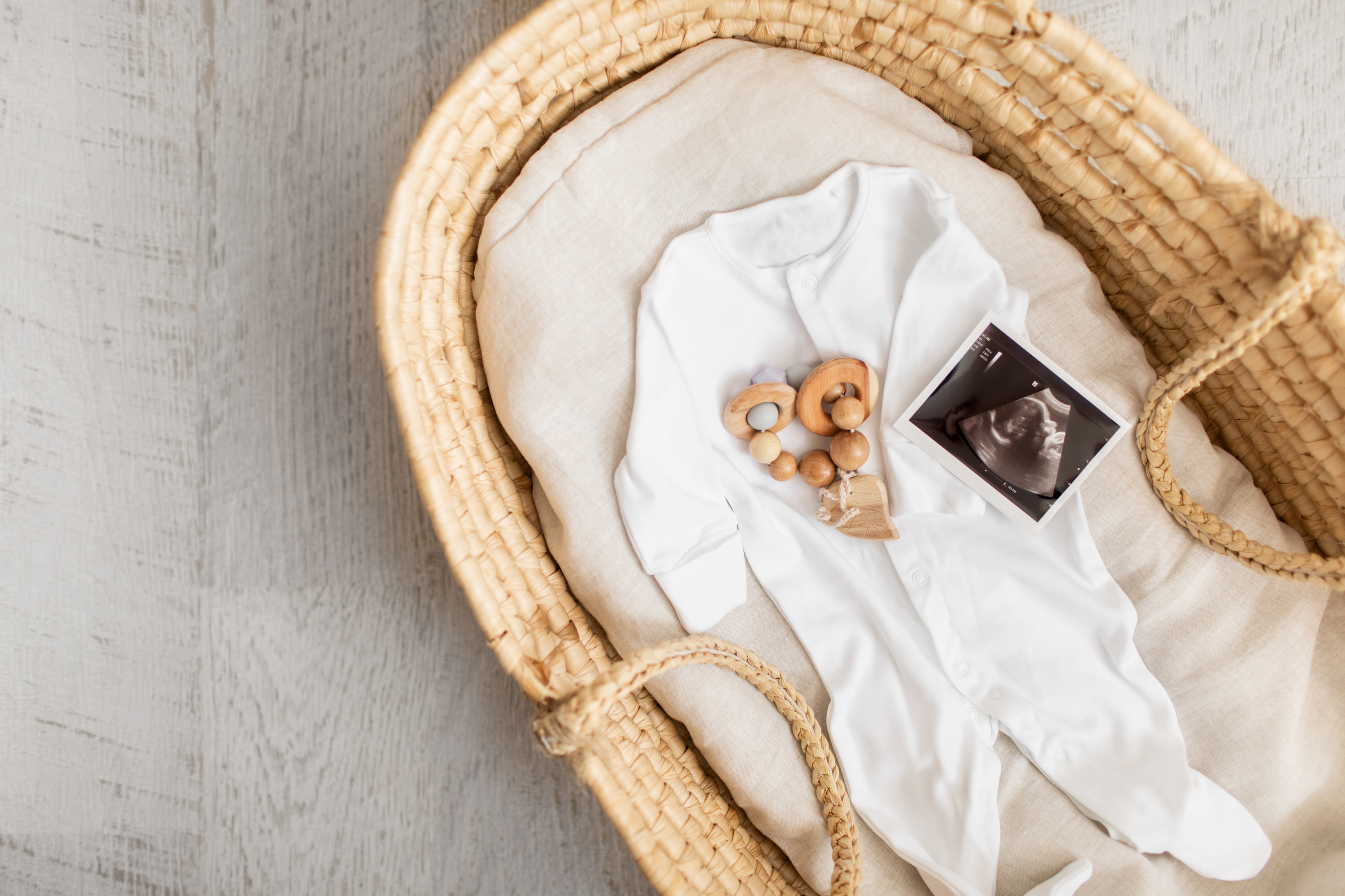 a baby onesie with an ultrasound picture in a basket