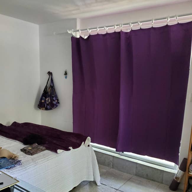 Purple black out curtains covering a window against a small wall