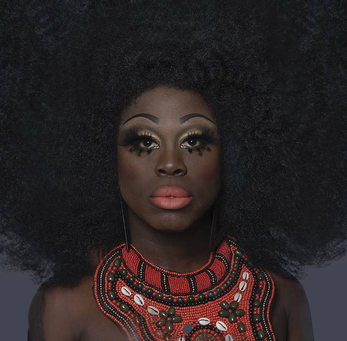 Close-up of Bob with a large Afro and coral lipstick with matching necklace