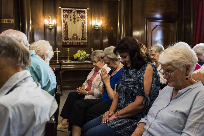 People bowing their heads in prayer in a church