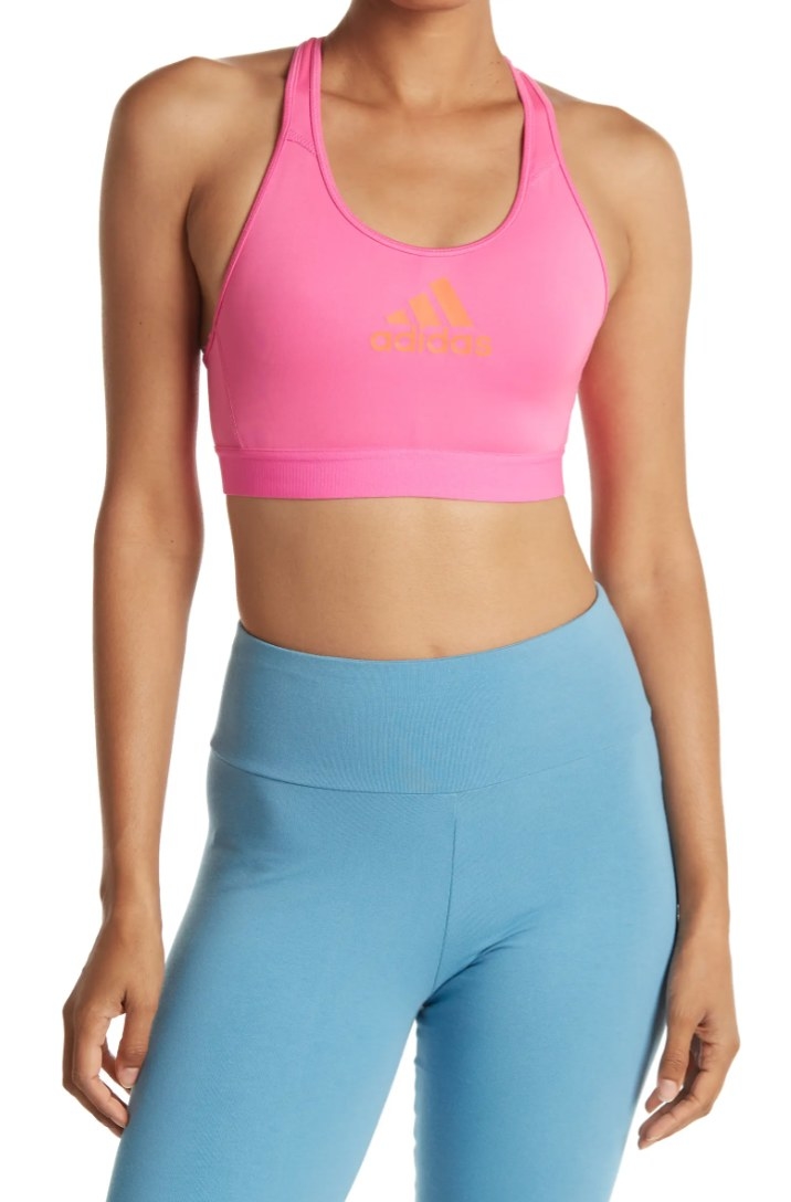 An Adidas sports bra in hot pink with an orange label