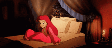 Gif of Arielle from The Little Mermaid happily getting into bed