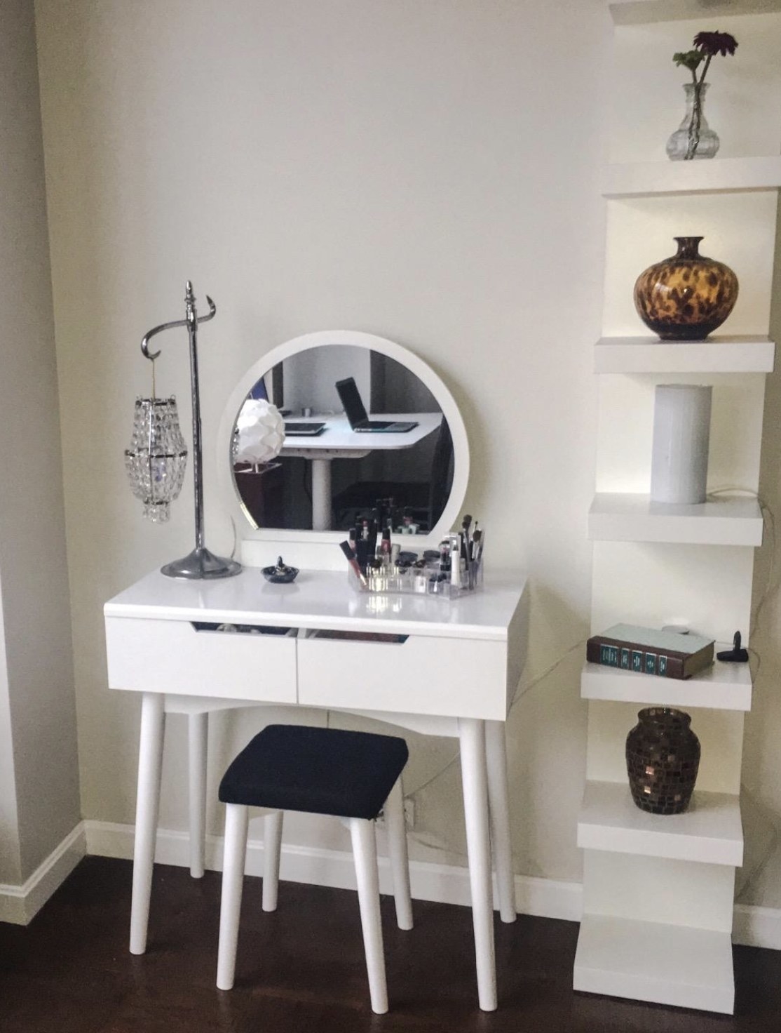 a vanity set in white with a round mirror, two drawers, and a stool
